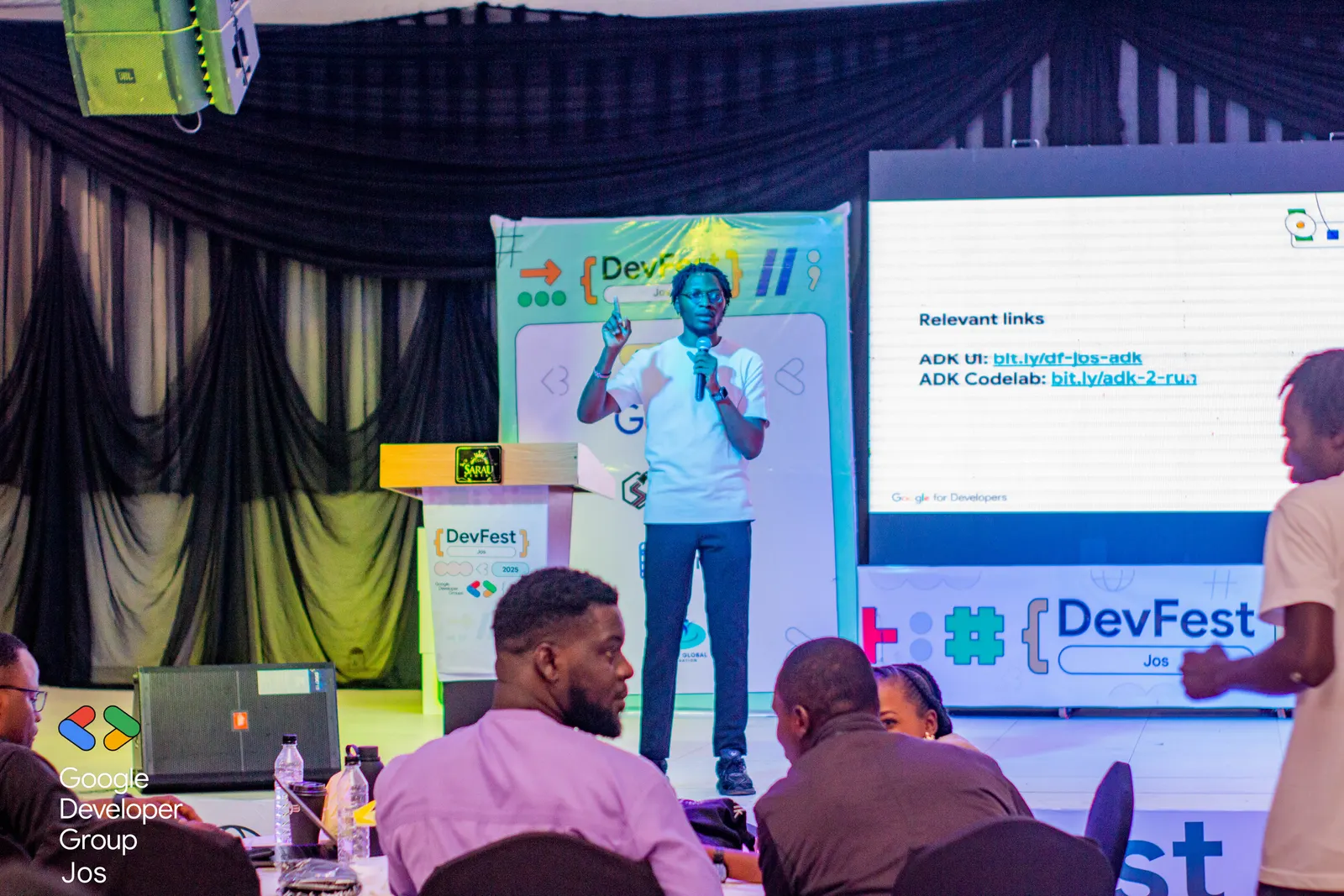 A speaker presenting on the DevFest Jos 2025 stage